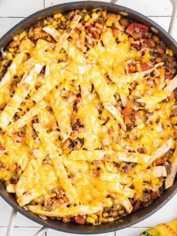 Taco skillet in pan topped with cheese.