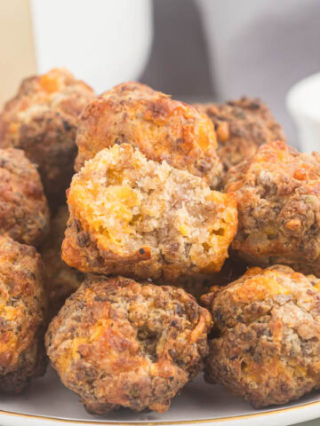Air fryer sausage balls on plate with bite taken.