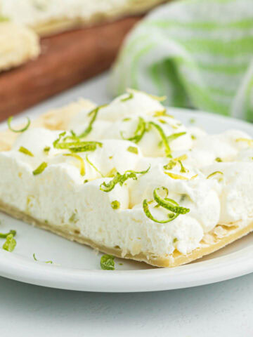 A serving of key lime tart on white plate.